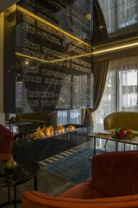 伊斯坦布尔佩科酒店的客厅设有壁炉、桌子和椅子