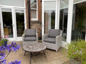 爱丁堡Braid Rd Stunning Villa的庭院设有两把椅子和一张茶几