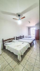 皮乌马POUSADA POLONINI - Localização ótima的一间卧室配有两张床和吊扇