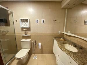 格拉玛多LUXUOSO APT ALMERIS PECCIN no Centro de GRAMADO的浴室配有卫生间、盥洗盆和淋浴。