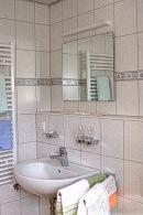 伦茨基希瓦尔德温克尔酒店的浴室配有盥洗盆、镜子和毛巾