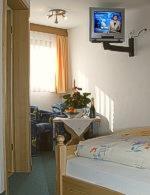 伦茨基希瓦尔德温克尔酒店的卧室配有一张床,墙上配有电视。