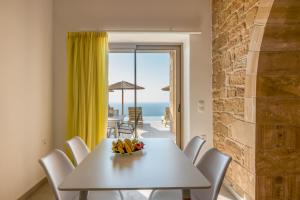 法拉萨纳Alma Natura Villas Falasarna- Aphroditi Villa的白色的用餐室配有桌子,享有海景