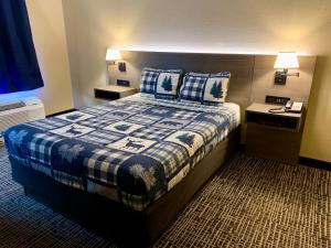 鸽子谷Riverchase Lodge的一间卧室配有一张带蓝白色毯子的床