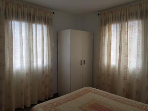 巴尔韦尔德Vv CASA JULIA的一间卧室配有床和两个带窗帘的窗户