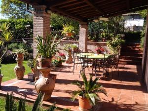 Genazzano吉拉索莱住宿加早餐旅馆的一个带桌椅和盆栽的庭院