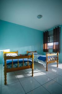 里奥格兰德Pousada Guarida的蓝色墙壁客房的两张床