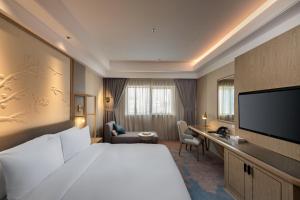 Al NamasAber Bani Amr的一间酒店客房,配有一张大床和一台平面电视