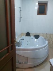 叶海格纳佐尔D&G guest house的门旁浴室内的白色浴缸