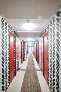 圣让-德吕兹Hotel Donibane Saint-Jean-de-Luz的走廊上设有红色和白色储物柜,走廊上设有长长的过道