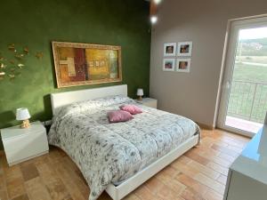 San Demetrio neʼ VestiniCasa Vacanze Boutique House Casa Mimo的一间卧室配有一张带两个粉红色枕头的床