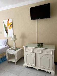 拉纳韦贝Lush Tropical apartment located in a 4-star resort的卧室配有一张床,墙上配有电视。