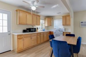 洛杉矶3 bedroom Mid-Wilshire Charmer near Downtown的厨房配有木制橱柜和一张带蓝色椅子的桌子。