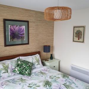 卡尔斯Maggie's Place in Cowes的一间卧室,床上有紫色花