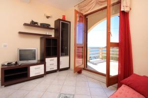 普利兹巴Apartments by the sea Karbuni, Korcula - 9308的一间带电视和滑动玻璃门的客厅