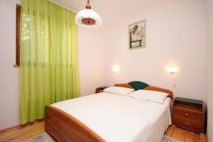 普利兹巴Apartments by the sea Karbuni, Korcula - 9308的一间卧室配有一张带绿帘的床