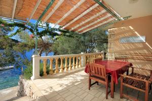 普利兹巴Apartments by the sea Karbuni, Korcula - 9308的阳台的天井配有桌椅