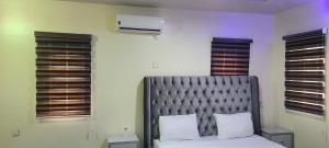 阿库雷Prince's - Villa - Minimum of 3 nights booking的一间卧室配有一张带灰色床头板和窗户的床。