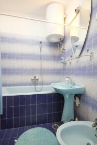 拉茨斯切Apartments by the sea Racisce, Korcula - 9337的蓝色瓷砖浴室设有水槽和镜子
