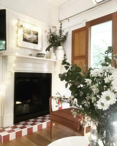 洛恩彼鲁兹洛恩酒店的客厅设有壁炉、椅子和鲜花