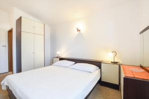 麦米科Apartments by the sea Marusici, Omis - 10012的卧室配有白色大床和橱柜