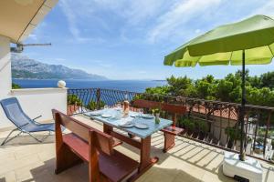 麦米科Apartments by the sea Marusici, Omis - 10012的一个带桌子和遮阳伞的庭院