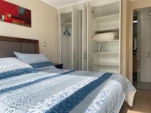 奇廉Departamento Chillan céntrico的卧室配有蓝色和白色的床和衣柜。