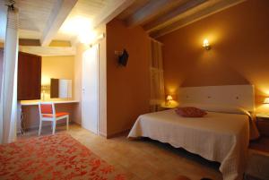 卡萨马卡里Pantanelli Di Vendicari的卧室配有1张床、1张桌子和1把椅子