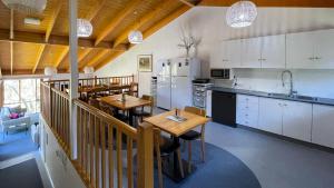 Baw Baw VillageTanjil Creek Lodge的一间带2张桌子的厨房和一间带白色橱柜的厨房