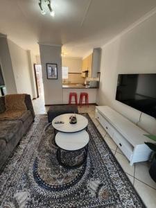 逊邱伦Elegant 2 bed apartment next to Gautrain Centurion的客厅配有沙发和桌子