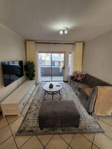 逊邱伦Elegant 2 bed apartment next to Gautrain Centurion的带沙发和电视的客厅