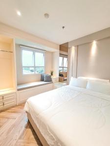 万隆R30 Apartemen Gateway Pasteur 2BR Daymentroom的卧室设有一张白色大床和一扇窗户。