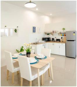 素可泰100sqm 2 bed apartment Sukhothai City的一间带桌椅的厨房和一间带冰箱的厨房