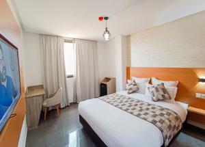 贝尼迈拉勒Hotel SunSet Beni Mellal的酒店客房,配有床和电视