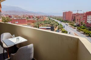 贝尼迈拉勒Hotel SunSet Beni Mellal的市景阳台配有桌椅