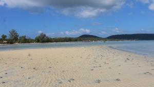 高龙撒冷岛Mangrove Beach Bungalows的沙滩上,沙滩上,水里,脚印