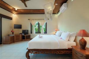 罗威那班亚里罗维纳温泉度假酒店的卧室配有一张白色大床和电视。