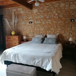 圣文森特德佩尔蒂尼亚Le Marronnier的一间卧室设有一张床和石墙