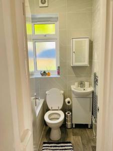 达格纳姆Superb and Comfortable 3BD Home in Dagenham的一间带卫生间、水槽和窗户的浴室