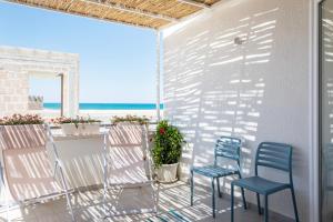 滨海波利尼亚诺Palamì - Polignano a Mare Holiday House的一个带桌椅的海景庭院