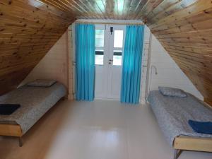 Cosy Holiday Home with sauna for family vacation的小房间设有两张床,配有蓝色窗帘