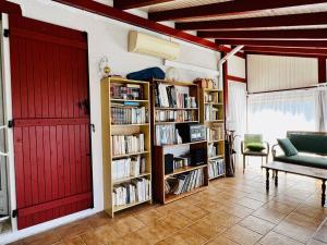 埃斯珀莱特Maison Espelette, 4 pièces, 5 personnes - FR-1-495-2的一间客厅,配有红色的门和书架
