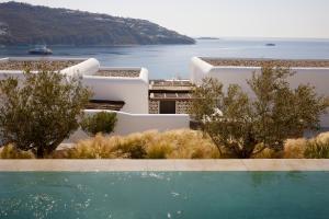 奥诺斯Kalesma Mykonos的水体前方设有游泳池的建筑