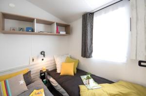 雷岛林滩Camping Le Suroit的小房间设有床和窗户