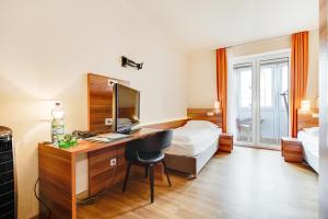萨尔茨堡阿斯托里亚酒店的酒店客房配有书桌和床。