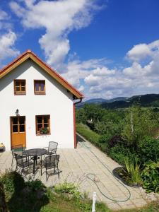 Frýdštejncharming house with beautiful landscape的白色的房子,在庭院配有桌椅