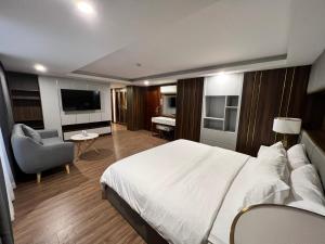 胡志明市Nam Hy 1 Hotel的酒店客房带一张大床和一把椅子