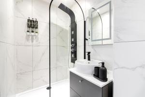 伦敦Majestic Luxury Apartment in Marylebone的带淋浴和盥洗盆的白色浴室