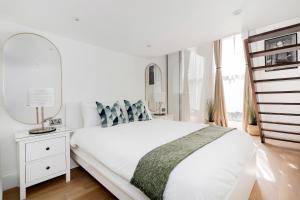伦敦Majestic Luxury Apartment in Marylebone的白色卧室配有床和镜子