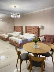 第比利斯Tbili Metekhi Boutique Hotel的一间卧室配有两张床、一张桌子和一张沙发